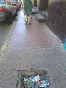 Huge hole in the sidewalk. These were everywhere and presumably designed to cripple unwary tourists.
